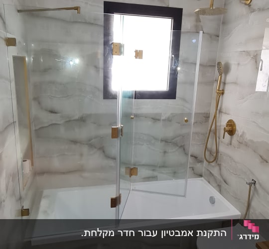 מקלחת עם דלת זכוכית וברז זהב